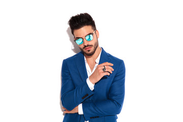 confident fashion man in sunglasses and blue coat