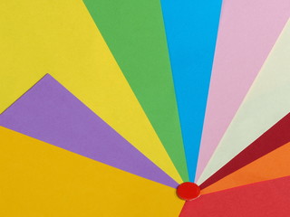 Colored paper background in a fan pattern with a red dot