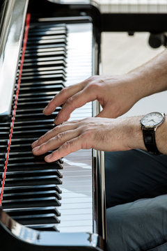 music performer hands playing grand piano. closeup view.