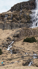 Trekking man scale with majestic waterfall mountain size. How powerful nature is compare to human