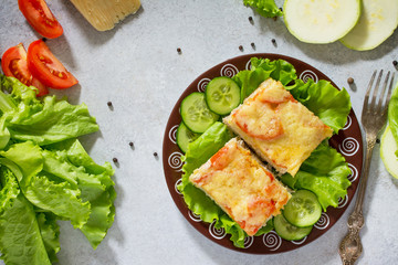 Сasserole zucchini with meat, rice, tomatoes and cheese on a gray stone background or slate. Top view.