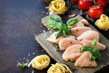 Fresh meat. Preparation of Italian cuisine pasta with chicken fillet, various spices and tomatoes...