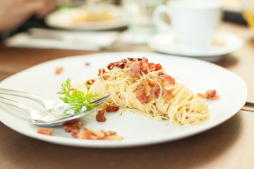 spaghetti becon on white plate in resturant