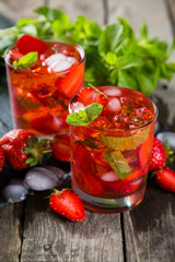Strawberry mojito and ingredients on rustic background
