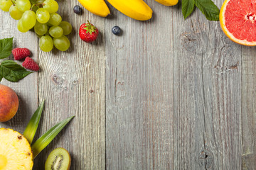Delicious fruit salad with fresh fruit. Wooden, gray table in the background.