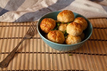 Chicken meatballs in a blue bowl on the table.