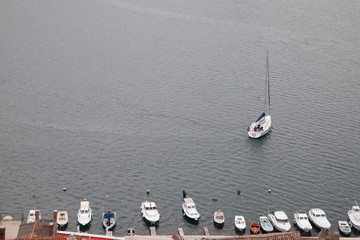 Sailing yacht passes by fishing boats near Sibenik, Croatia 