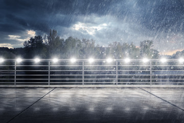 Brücke an einem See bei Nacht im Regen
