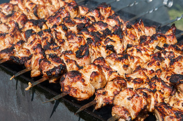 Grilled kebab cooking on metal skewer. Roasted meat cooked at barbecue. BBQ fresh beef meat chop slices. Grill on charcoal and flame, picnic, street food