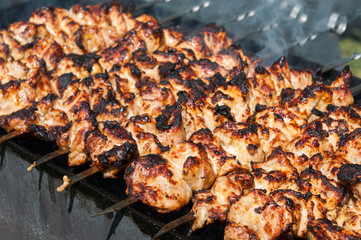 Grilled kebab cooking on metal skewer. Roasted meat cooked at barbecue. BBQ fresh beef meat chop slices. Grill on charcoal and flame, picnic, street food