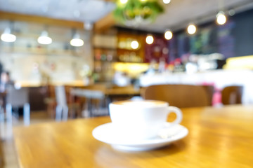 Blur coffee shop interior with a cup of coffee on the table