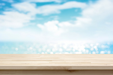 Wood table top on blur sparkling sea water and summer sky background