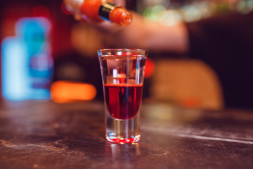 A cocktail made by layers. Shot at the bar.