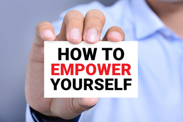 HOW TO EMPOWER YOURSELF message on the card shown by a man