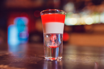 A cocktail made by layers. Shot at the bar.
