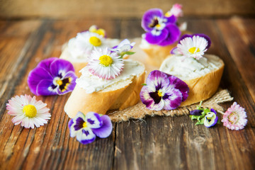 Obraz na płótnie Canvas Sandwich with herb and edible flowers butter on marble cutting board. Healthy food.