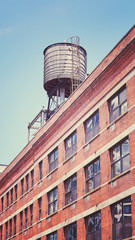 Vintage toned picture of a rooftop water tank on a New York city apartment building, USA.