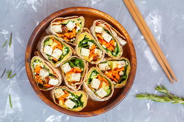 Healthy vegan tofu tortilla wraps with tofu and vegetables, top view. Love for a healthy raw food concept.