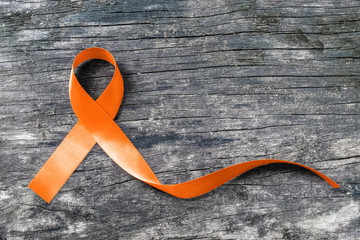 Orange ribbon for Leukemia, Kidney cancer, RDS multiple sclerosis awareness on helping hand...