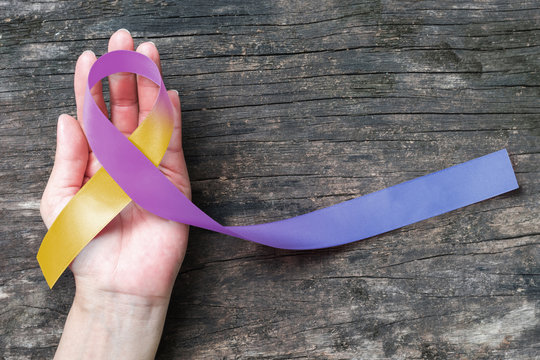 Bladder cancer awareness marigold blue purple ribbon  (isolated with clipping path)  symbolic color on helping hand support