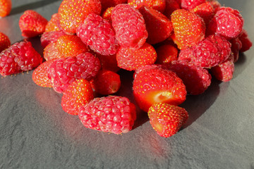 Domestic strawberry and rapsbery on marble texture