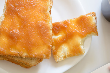 Tasty breakfast. Toasts with butter and jam on a plate. Cup of coffe.