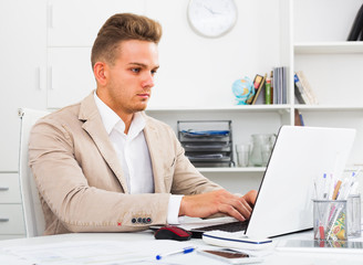 Man working with documents and laptop