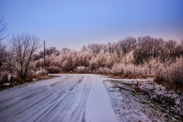 Fototapeta na wymiar A snow covered gravel road in a rural area