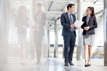 Businessman and businesswoman discussing work while walking