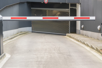 Einfahrt einer Tiefgarage mit Tor und Schranke