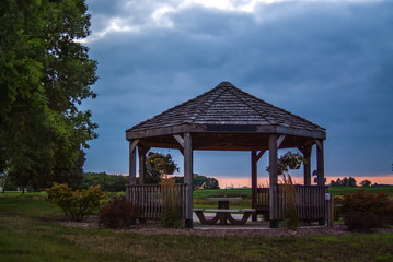 Fototapeta na wymiar large rustic gazebo with a picnic table in the center