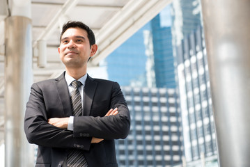 Fototapeta premium Asian businessman standing and crossing his arms