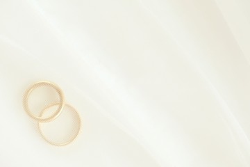 Closeup of two wedding rings under white bridal veil