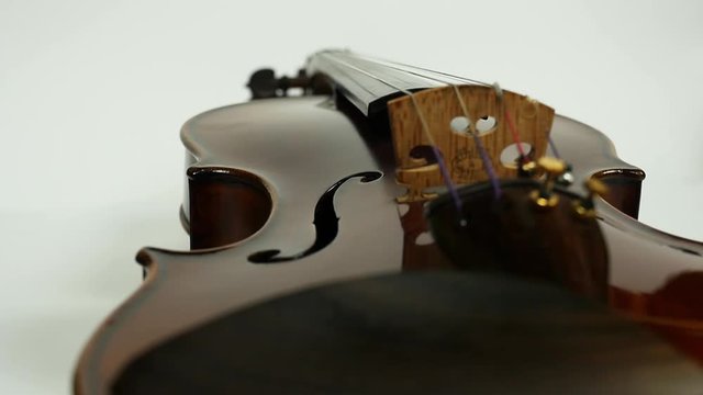 Close up violin and bow on white background. View from the side of violinist.