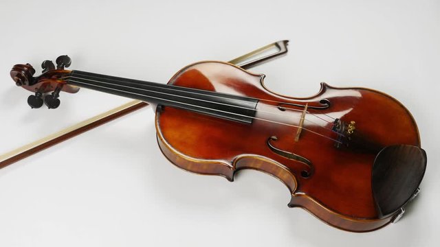 Top view of the violin and a bow near it. Bow under the violin