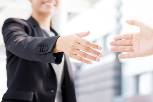 Businesswoman going to make handshake with a businessman