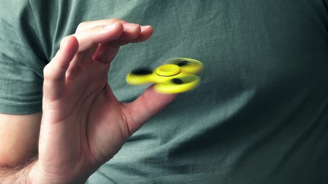 Man playing with fidget spinner, very popular modern toy for relaxation and stress relief