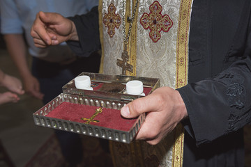 The priest holds church utensils, glans, ceremony of water baptism, various objects needed for baptism christening