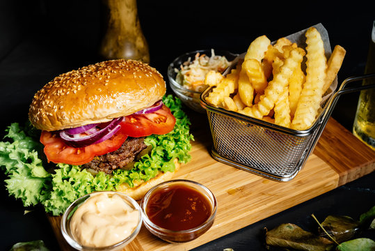 Tasty, delicious, beef burger with fresh vegetables, fries and coleslaw