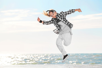 Fashion child dancing over sky background.