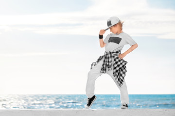 Fashion child dancing over sky background.