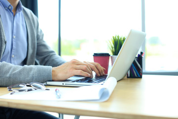 Young businessman working with laptop at office.