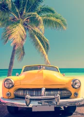 Fotobehang Klassieke auto op een tropisch strand met palmboom, vintage proces © Delphotostock