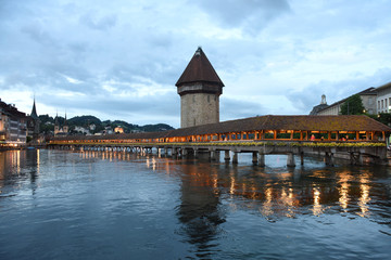 Lucerne cityscape at night Switzerland. Chapel Bridge (Kapellbrucke) and Water Tower on Lake...