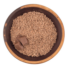 Grated chocolate in a ceramic plate. Isolated on white background.