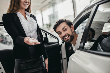 Salesperson with customer in car dealership