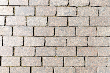 Stone granite cobblestoned pavement background or texture. Abstract background of old cobblestone pavement