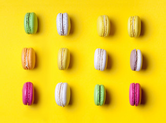 Sweet colorful macaroons on yellow background