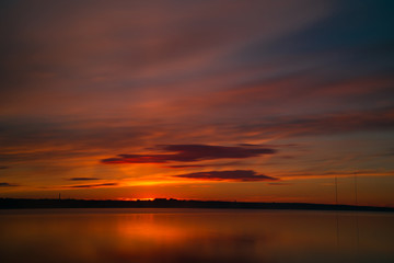 Naklejka na ściany i meble Orange and red sunset at coast of the lake