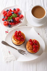 Coconut muffins with currants and coffee with milk close-up on the table. vertical top view